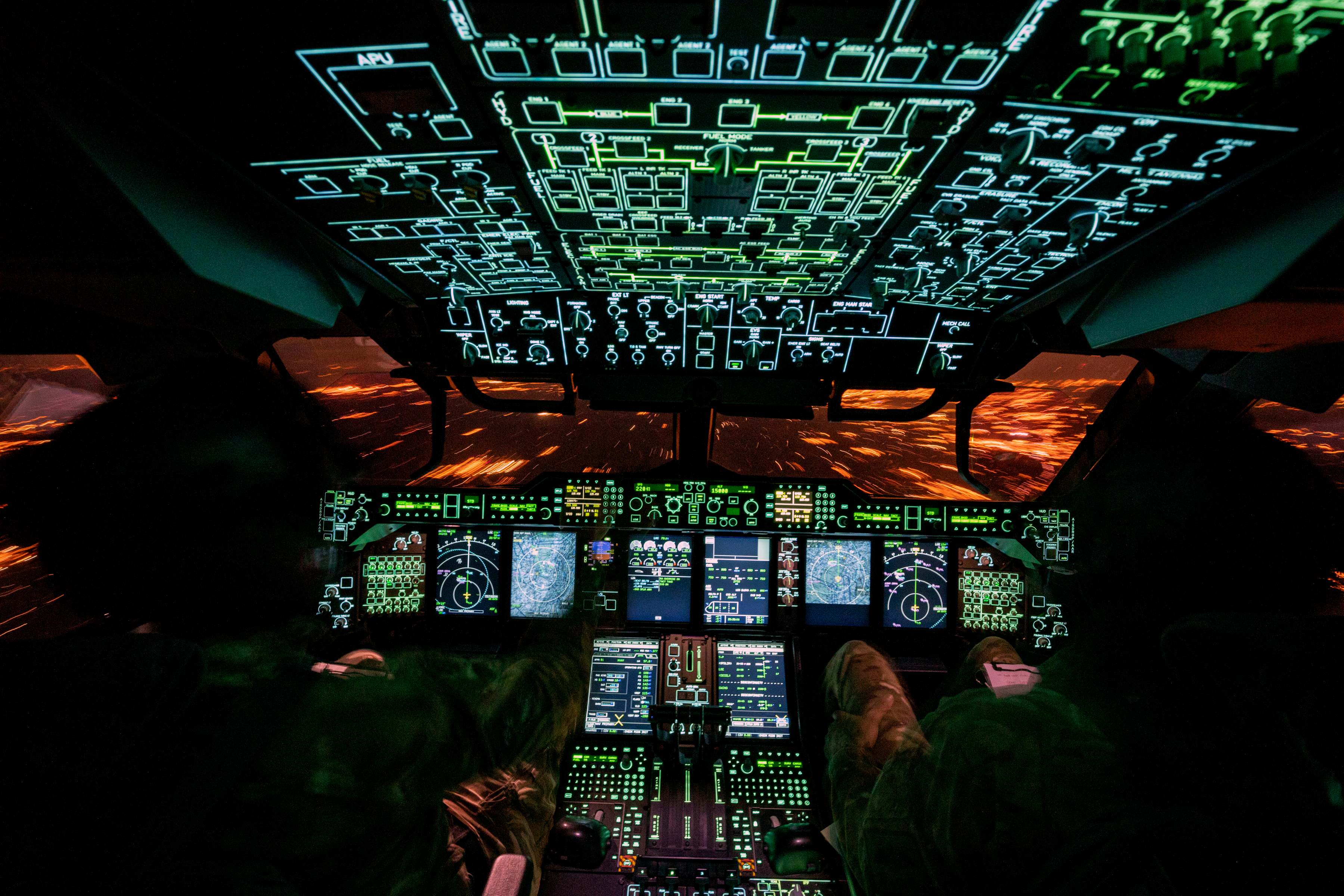Cockpit of RAF plane at night, all the instruments lit up and displaying information 