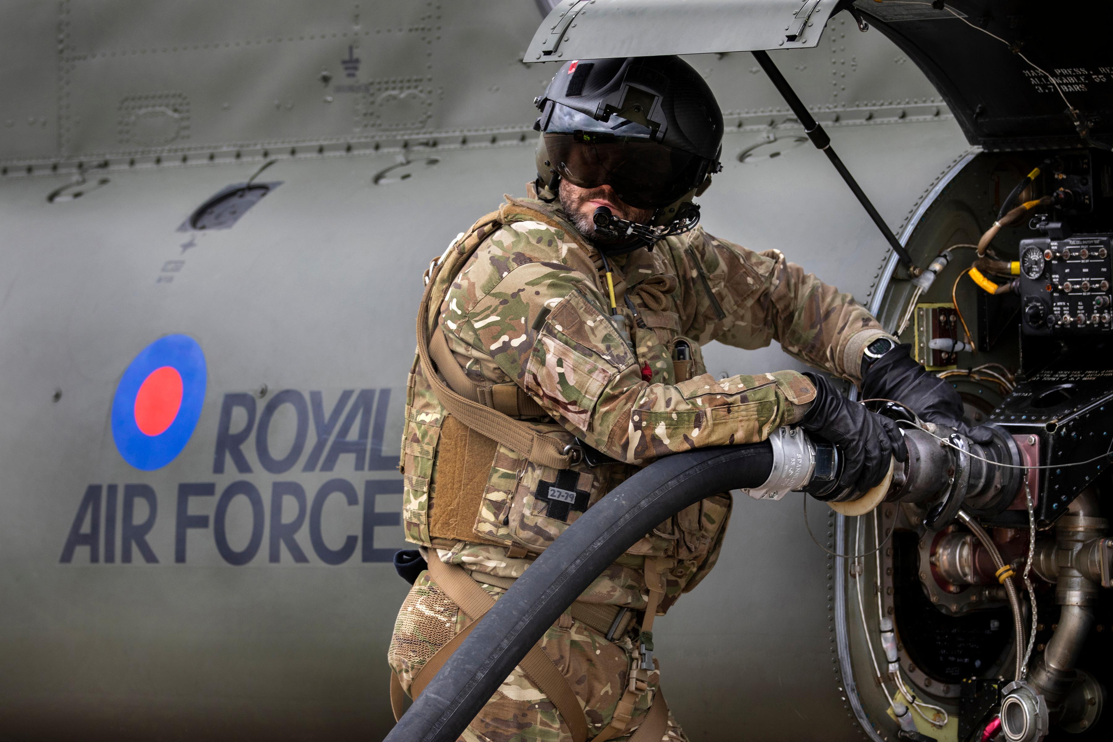 RAF Engineer, in uniform with a helmet on refuelling plane